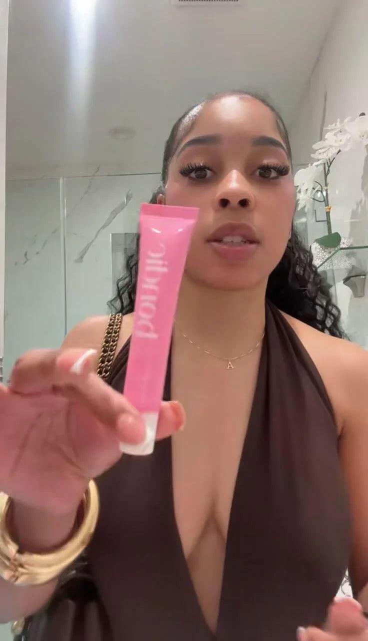 Femme tenant une colle corporelle rose résistante à l'eau et à la transpiration pour vêtements
